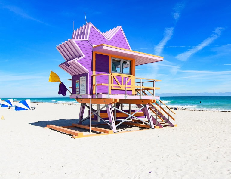 Cabine de sauveteurs violette et jaune sur une plage de Miami Beach.
